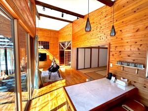 Cette chambre est dotée de murs en bois et de parquet. dans l'établissement ＨARUNA VILLA 浅間山麓、貸切コテージ、アクセス抜群, à Kita-karuizawa