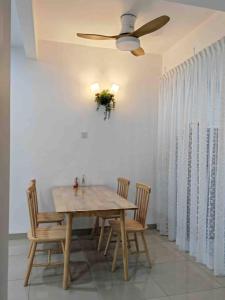 Kapar的住宿－Super cozy house，餐桌、椅子和吊扇