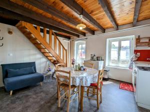 a kitchen and dining room with a table and a blue couch at Évasion au cœur de Polignac : Charme et confort à deux pas du Puy-en-Velay - FR-1-582-382 in Polignac +24 photos