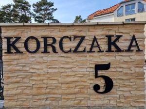 ein Zeichen für Kopera an einer Ziegelmauer in der Unterkunft White Resort in Krynica Morska