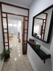 un pasillo con un espejo en la pared en Precioso apartamento en Sevilla., en Camas