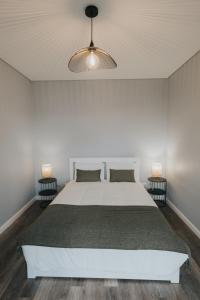 ein Schlafzimmer mit einem weißen Bett und zwei Lampen in der Unterkunft Pico Apartment's in Câmara de Lobos