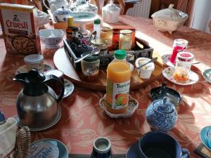 einem Tisch mit Essen und einem Krug Orangensaft in der Unterkunft Guestroom Lassay-les-Châteaux, 1 pièce, 2 personnes - FR-1-600-231 in Niort-la-Fontaine