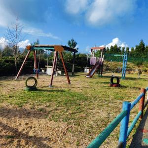 einen Spielplatz mit zwei Schaukeln auf einem Feld in der Unterkunft Eirixo in Valga