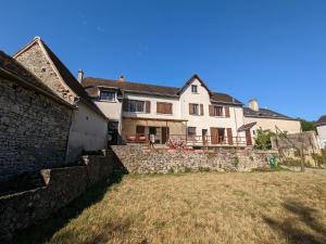 una grande casa bianca con un muro di pietra di Gîte Lurais, 3 pièces, 5 personnes - FR-1-591-430 a Lurais