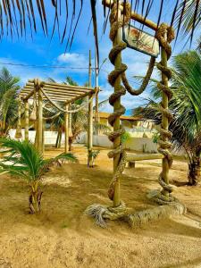 ein Baum mit einem Schild in der Mitte eines Hofes in der Unterkunft Casa de Praia - Aracaju - Jatobá in Barra dos Coqueiros