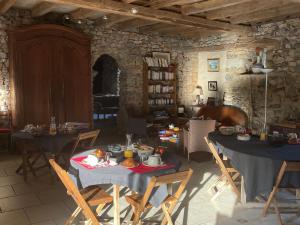 un soggiorno con due tavoli e sedie con sopra il cibo di Charmantes chambres d'hôtes avec piscine et coin cuisine près de l'abbaye de Solesmes - FR-1-410-404 a Solesmes