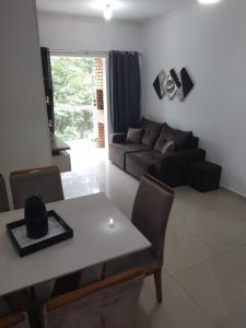 a living room with a table and a couch at APARTAMENTO INTEIRO BELA ARTE COSTA E SILVA, 2 QUARTOS in Joinville