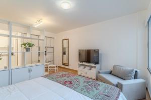 a bedroom with a bed and a tv and a couch at Hermoso Departamento en Palermo! in Buenos Aires