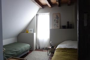 a bedroom with two beds and a window at la maison haute in Toucy +8 photos