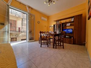 a dining room with a table and chairs and a tv at Il Paradiso di Rosalba by Holiday World in Ficarazzi