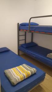 a blue bunk bed with a striped towel on it at Albergue Santiago Apostol in Logroño