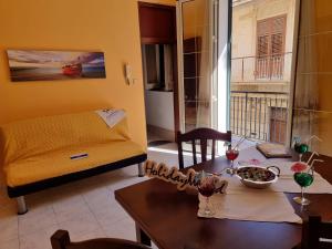 uma sala de estar com uma mesa e um sofá em Il Paradiso di Rosalba by Holiday World em Ficarazzi