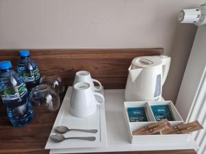 a white counter with spoons and bottles of water at White Resort in Krynica Morska