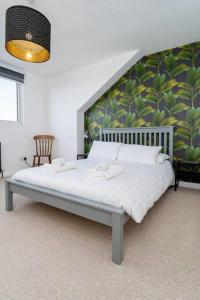 a bedroom with a white bed with a green wall at Light bright & contemporary split-level apartment in Brighton & Hove