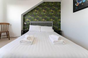 a bedroom with a bed with towels on it at Light bright & contemporary split-level apartment in Brighton & Hove