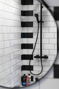 a bathroom mirror with a black and white tile wall at Light bright & contemporary split-level apartment in Brighton & Hove