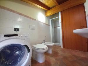 a bathroom with a washing machine and a toilet at CASA VACANZE TANIA in Somendenna +18 photos