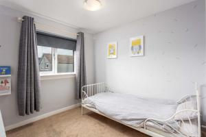 a white bedroom with a bed and a window at 33 Lochgreen Avenue in Troon