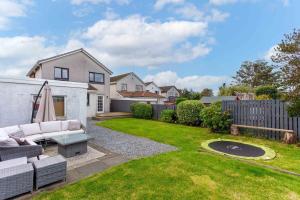 a backyard with a white couch in the grass at 33 Lochgreen Avenue in Troon