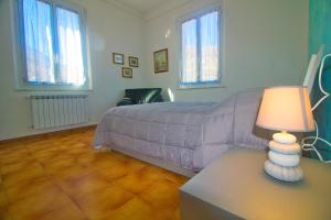 sypialnia z łóżkiem i lampką na stole w obiekcie PAPAPEO w mieście La Spezia