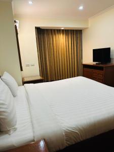 Omni Tower Sukhumvit Nana by Direct Rooms في بانكوك: غرفه فندقيه سرير وتلفزيون