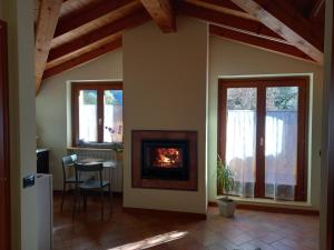 a living room with a fireplace and a table at CASA VACANZE TANIA in Somendenna