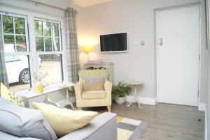 uma sala de estar com um sofá e uma cadeira em Secret Mersea Retreat - a stroll from the anchorage! em West Mersea