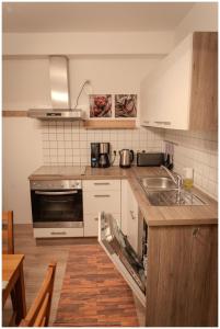 cocina con fregadero y fogones horno superior en Appartement Franz, en Bad Ischl