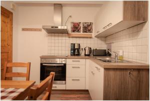 a kitchen with a stove and a sink and a table at Appartement Franz in Bad Ischl +9 photos