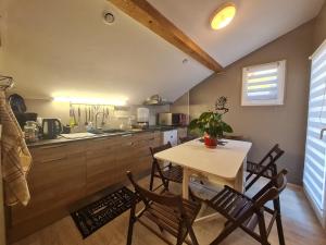 uma cozinha com mesa e cadeiras num quarto em Guestroom Rochesson, 1 pièce, 4 personnes - FR-1-589-565 em Rochesson