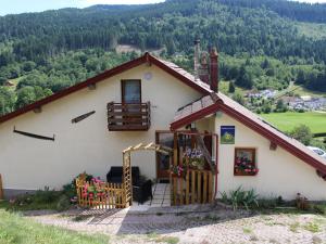 a small white house with a porch and a balcony at Chambre double confortable avec accès indépendant à Rochesson, près de Gérardmer - FR-1-589-575 in Rochesson
