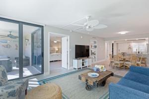 a living room with a blue couch and a table at Loggerhead 261 in Sanibel