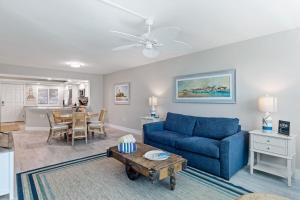 a living room with a blue couch and a table at Loggerhead 261 in Sanibel