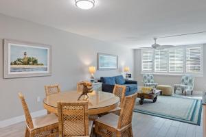 a living room with a table and a blue couch at Loggerhead 261 - Gorgeous Residence at Loggerhead Cay with Fantastic Amenities in Sanibel