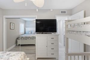 a bedroom with a bunk bed and a television at Loggerhead 261 in Sanibel