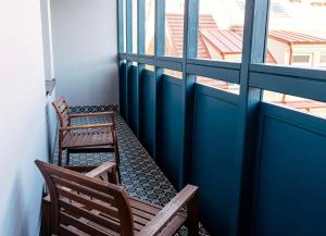 two chairs sitting on a balcony with two windows at The Hotel Fitzgerald in Prague