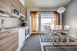 a kitchen with a table with chairs and a dining room at Skivillas 28 A 3 in Ukkohalla