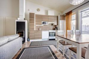 a kitchen and living room with a table and a couch at Skivillas 28 A 3 in Ukkohalla