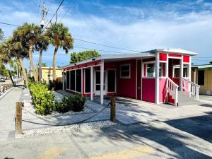 ein rotes Gebäude mit Palmen davor in der Unterkunft Sunrise Tiny Home - New&Cozy in Sarasota