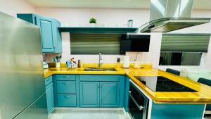 a kitchen with blue cabinets and a yellow counter top at Sunrise Tiny Home - New&Cozy in Sarasota