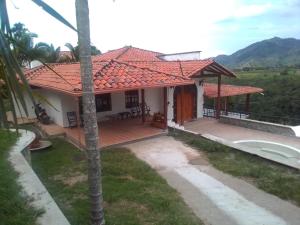 une maison avec un toit rouge et une terrasse dans l'établissement Finca Vista Primorosa, à Pereira