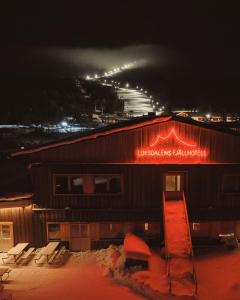 a building with a sign on the side of it at night at Lofsdalens Fjällhotell & Hotellbyns lägenheter in Lofsdalen
