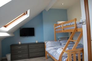 a bedroom with a bunk bed and a television at Idris View Family Holiday Home in Tywyn