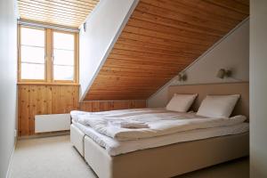 a bedroom with a large bed with a wooden ceiling at Lofsdalens Fjällhotell & Hotellbyns Lägenheter in Lofsdalen