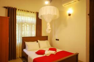 a bedroom with a bed with two pillows on it at Punida villa in Matara