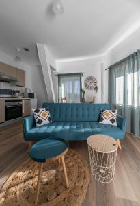 un salon avec un canapé bleu et une cuisine dans l'établissement Résidence Nature - Appartements design en centre ville, à Cusset
