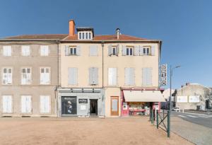 un vieux bâtiment au coin d'une rue dans l'établissement Résidence Nature - Appartements design en centre ville, à Cusset