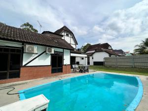 a swimming pool in front of a house at Private Pool Villa Lot 872 - Fong Homestay in Kampong Alor Gajah