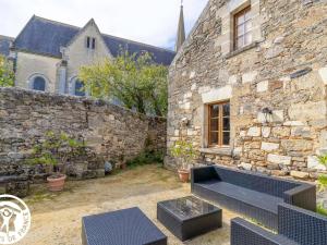 un bâtiment en pierre avec un banc devant lui dans l'établissement Guestroom Doué-en-Anjou, 1 pièce, 2 personnes - FR-1-622-63, à Méa